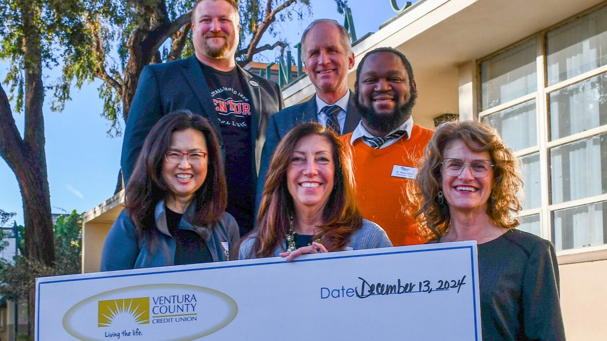 College foundation board holding grant check