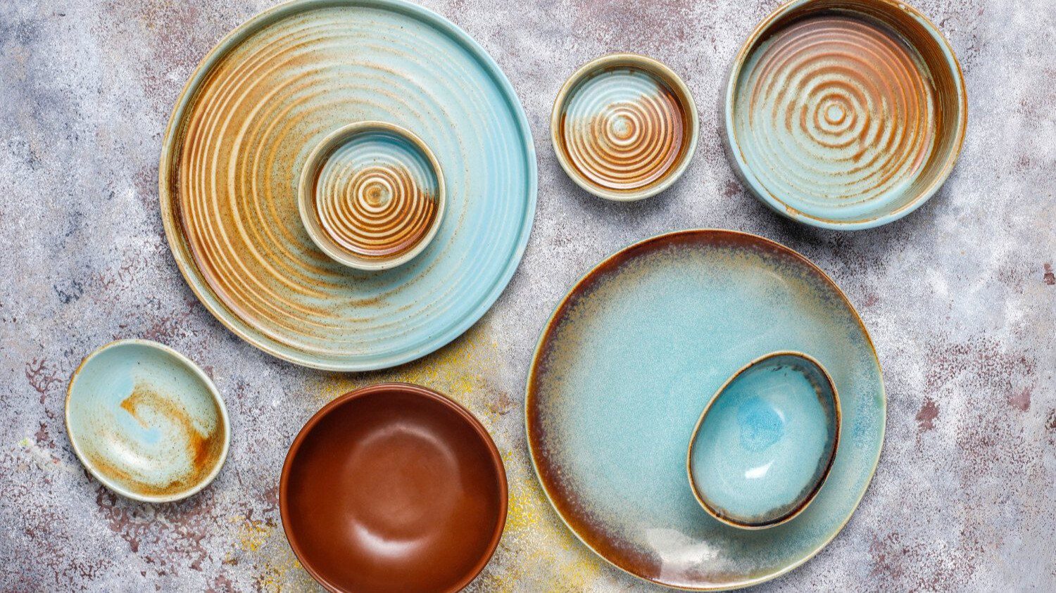 Assortment of artistic ceramic plates and bowls.