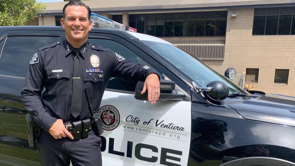 New Ventura Police Chief, David Dickey standing in front of a police car.