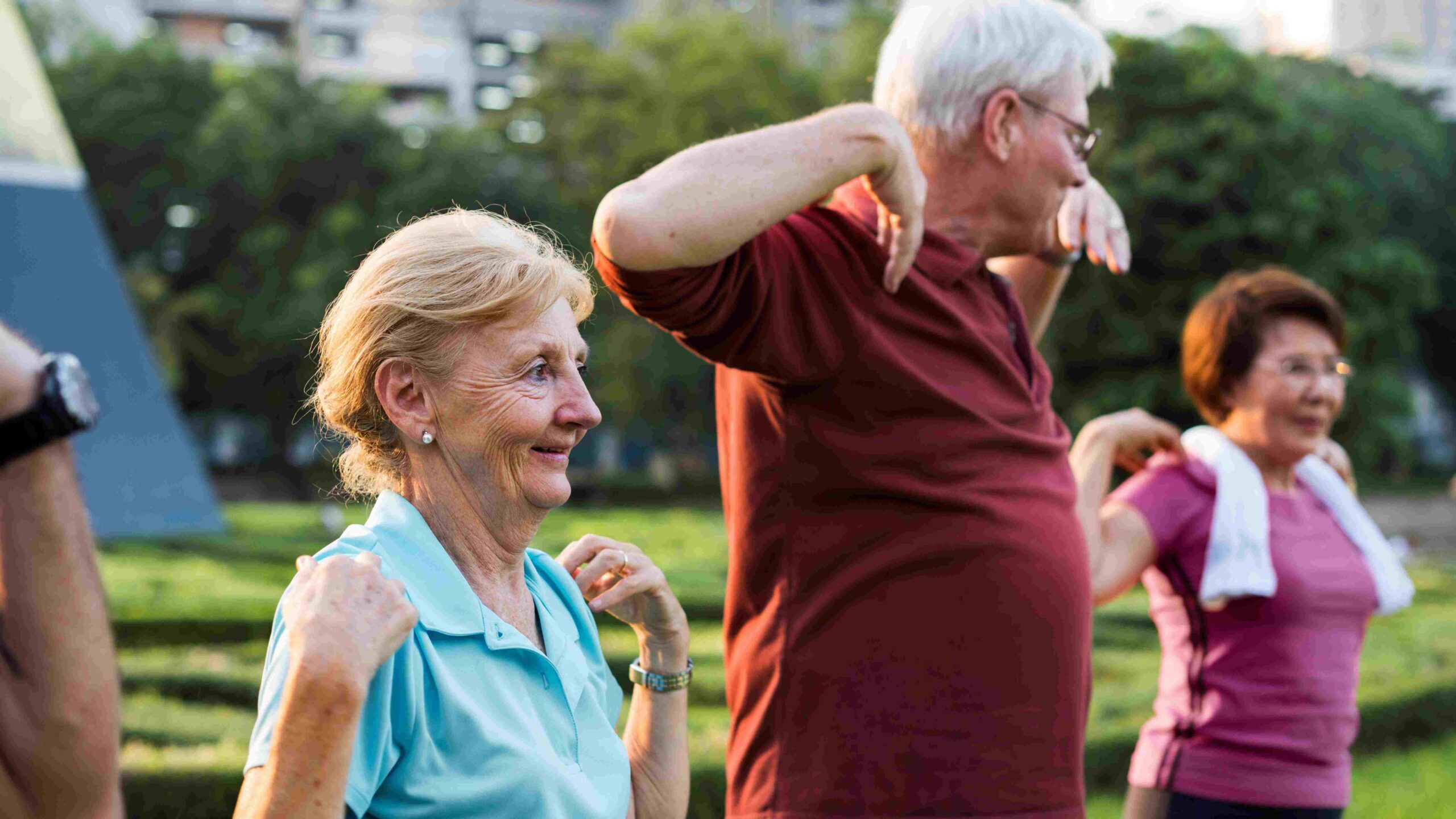 Three seniors outdoors doing exercises.