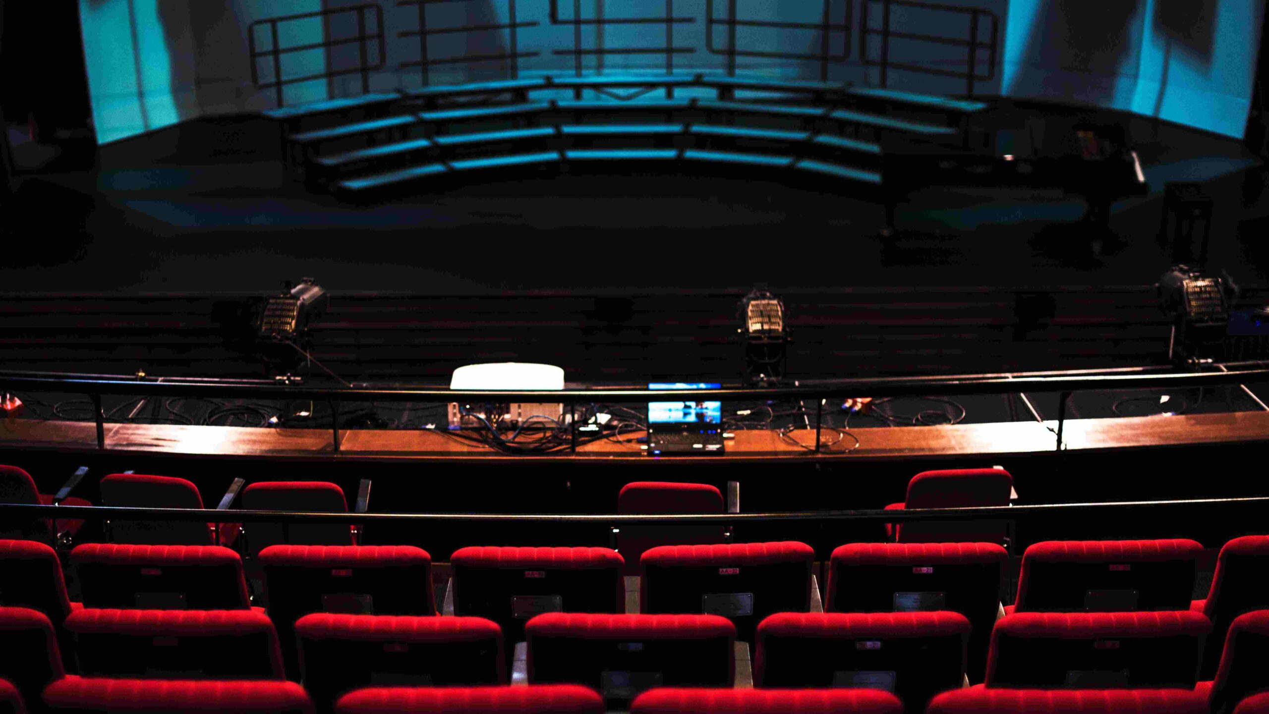 Rows of red seats in an empty theater.