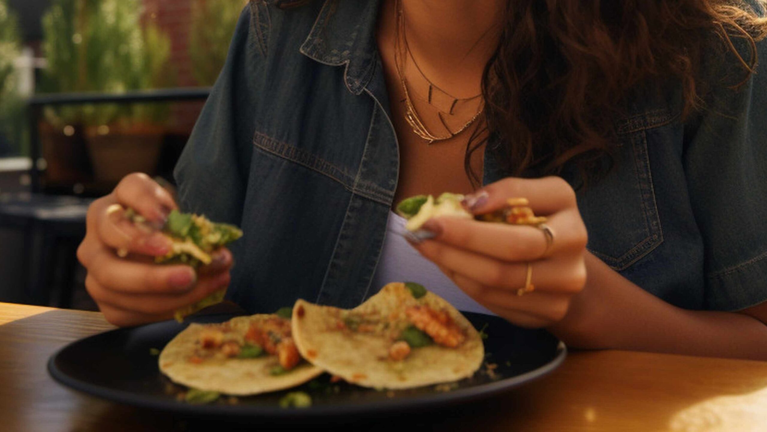 Person eating tacos in restaurant