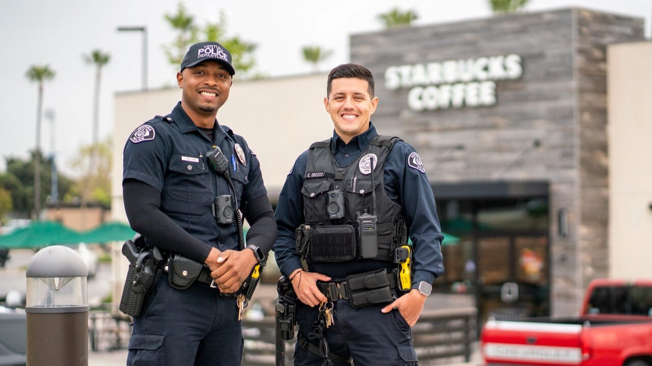 Two VPD officers posing for a photo at a strip mall in Ventura.