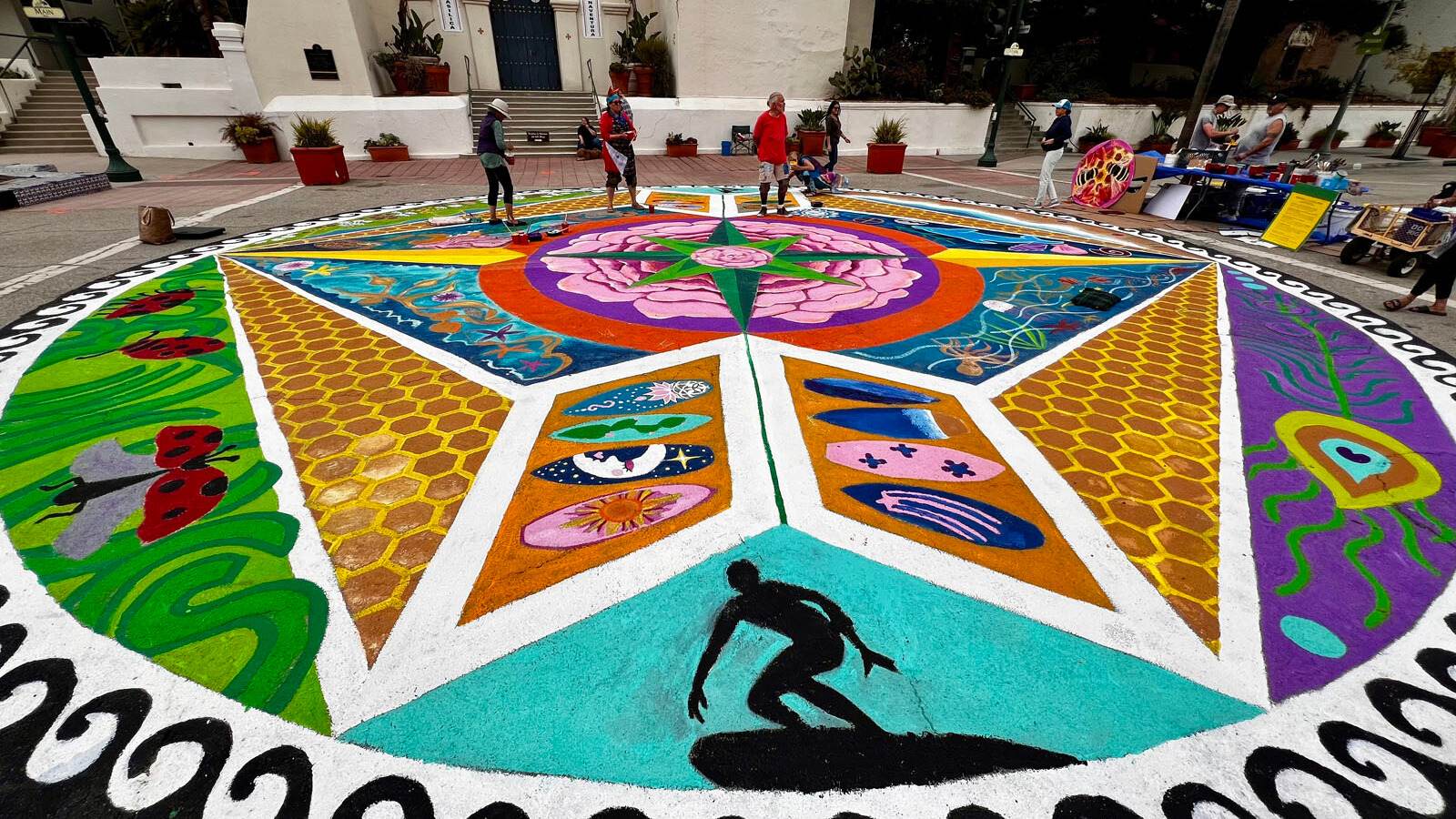 A vibrant mandala design in front of the historic San Buenaventura Mission.