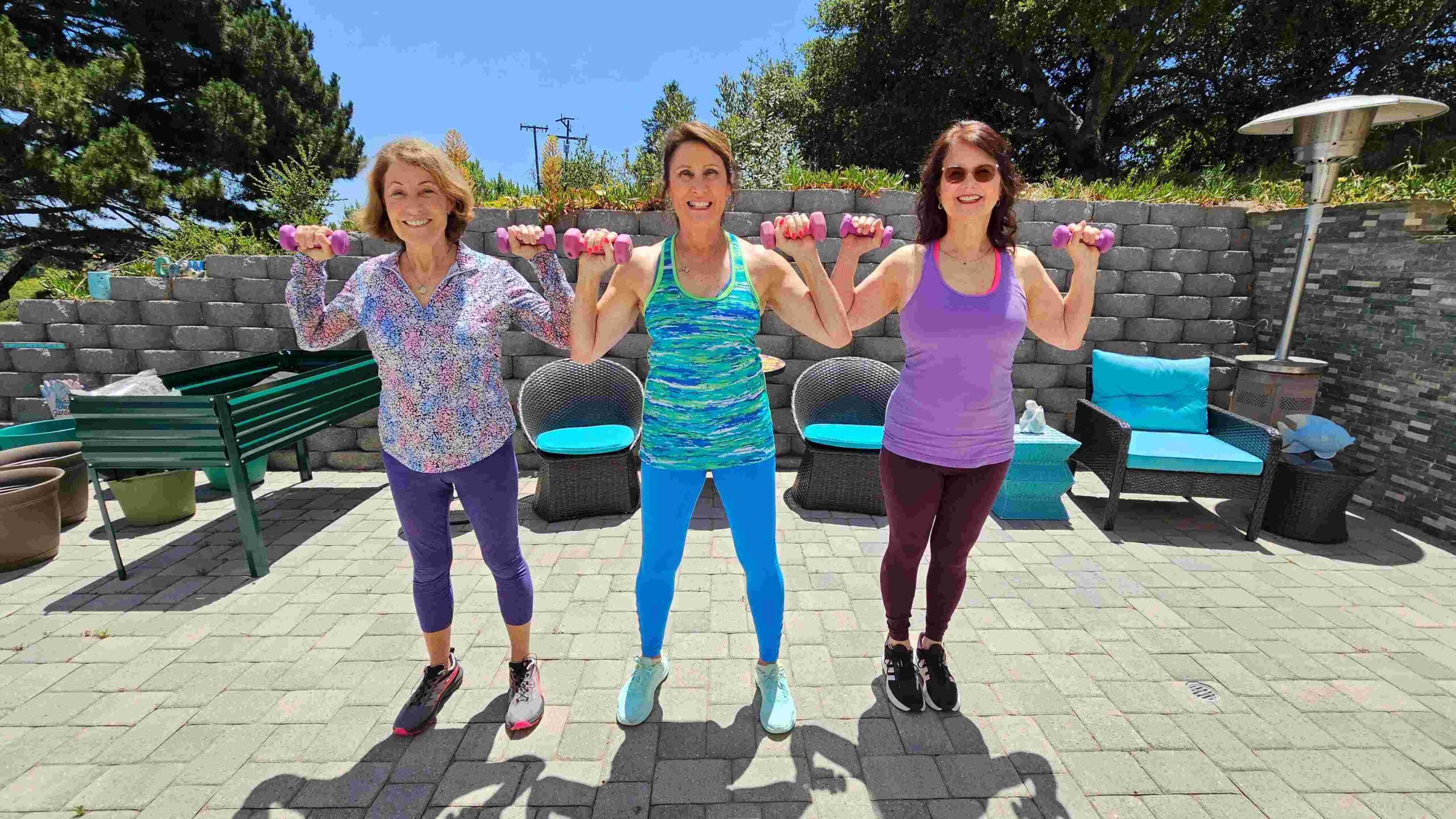 Leslie Sokol (center) teaching a fitness class with two female attendees.