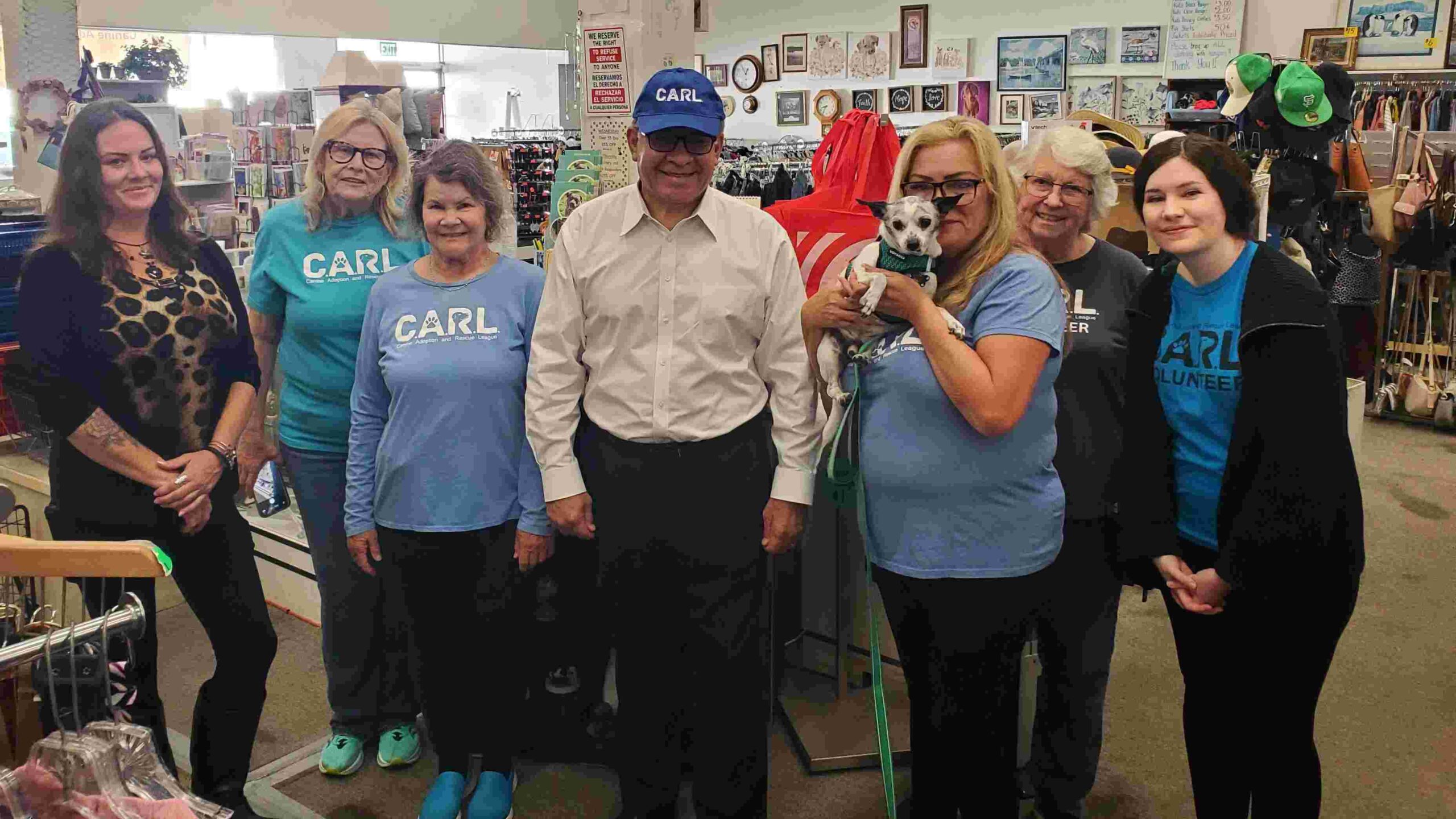 Senator Carbojal wearing a CARL hat in the CARL boutique with volunteers.