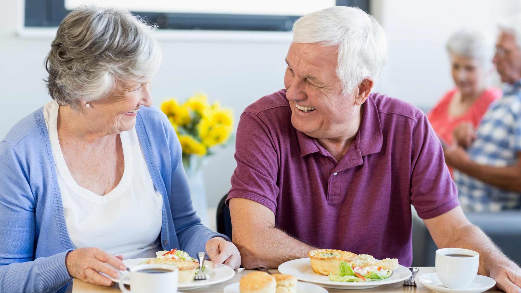 Seniors sitting at table with food