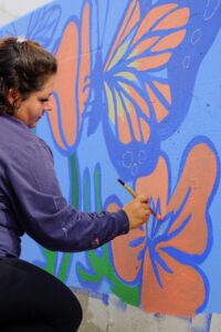 Woman painting on Moon Mural Ditch